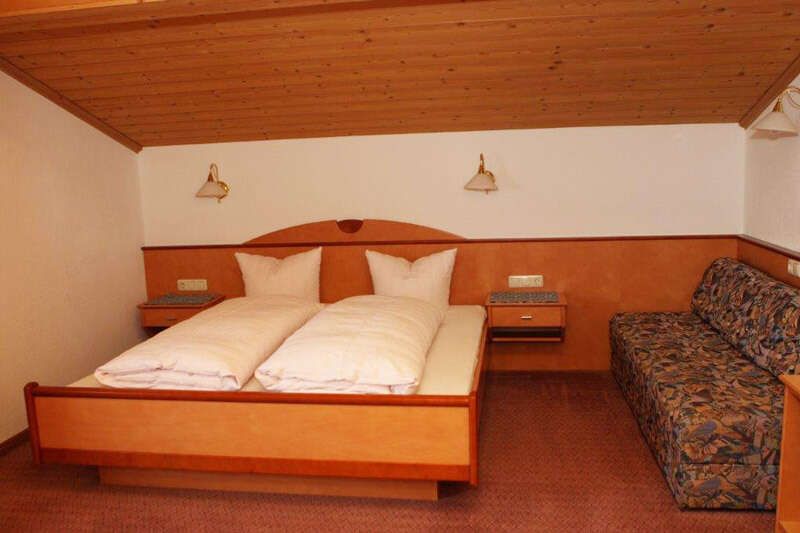 Bedroom with double bed and sofa bed in apartment 320 in the Hotel Garni Sonnenheim