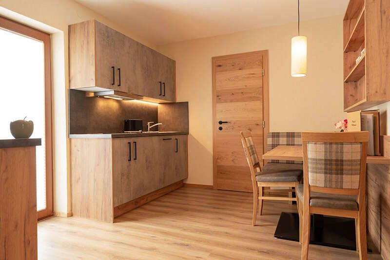 Wohnbereich mit Küche im Appartement 211 im Hotel Garni Sonnenheim in Fiss